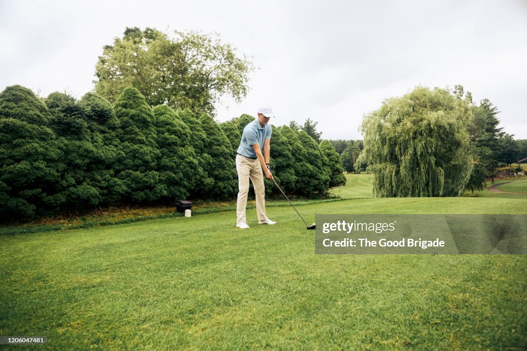 Male golfer preparing to hit tee shot