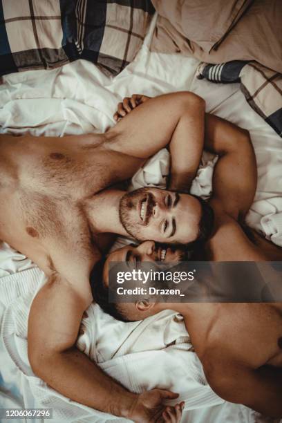 partially naked lgbt gay couple at home resting and hugging - gay love stock pictures, royalty-free photos & images