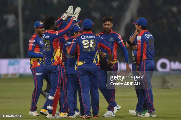 Karachi Kings's Mohammad Amir celebrates with teammates after the dismissal of Lahore Qalandars's Fakhar Zaman unseen during the T20 cricket match...