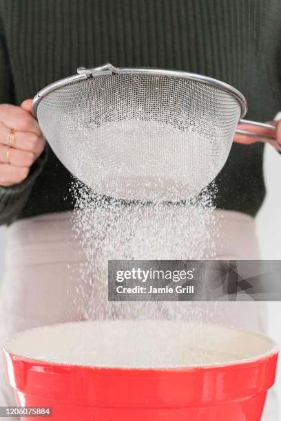 woman sifting flour into bowl - sieve stock pictures, royalty-free photos & images