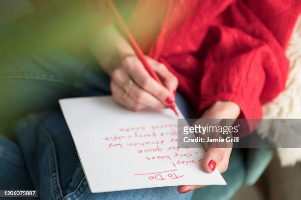woman writing 'to do' list - liste stock pictures, royalty-free photos & images