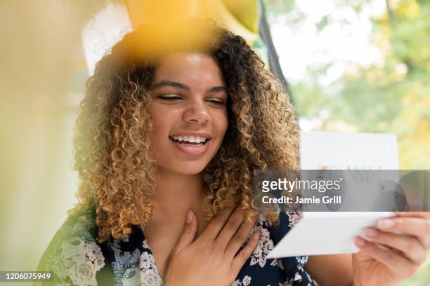 smiling woman reading thank you card - thank you smile stock pictures, royalty-free photos & images