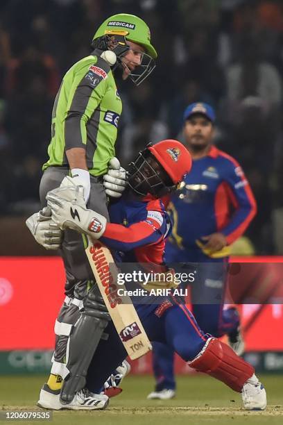 Karachi Kings's wicketkeeper Chadwick Waltaon attempts for a catch of Lahore Qalandars's Ben Dunk during the Pakistan Super League T20 cricket match...