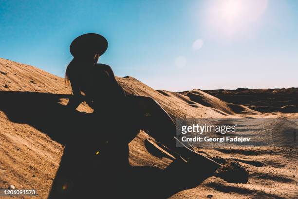 silhouette of girl sitting on the sand, desert. blue sky. - hot arabic women fotografías e imágenes de stock