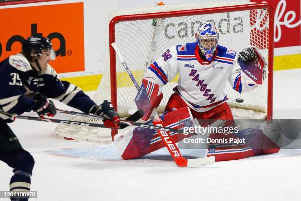 Goaltender Jacob Ingham of the Kitchener Rangers watches a deflected puck by forward Curtis Douglas of the Windsor Spitfires at WFCU Centre on March...