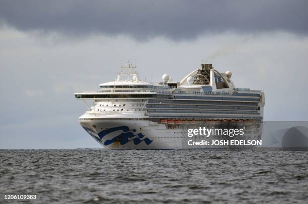 People look out from aboard the Grand Princess cruise ship, operated by Princess Cruises, as it maintains a holding pattern about 25 miles off the...