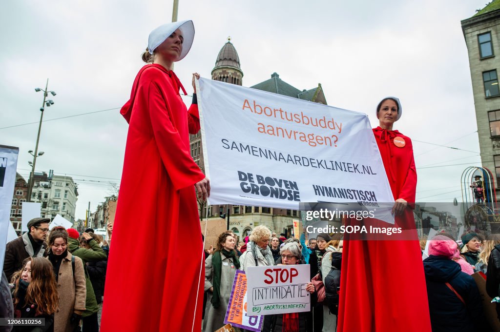 Two women wearing the Handmaid´s Tale costumes hold a big...