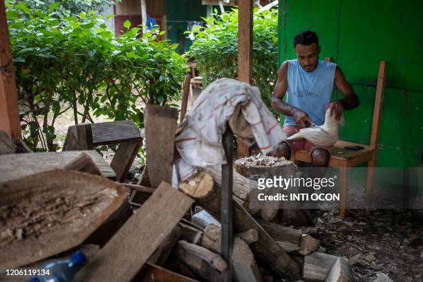 Craftsman sculpts a toucan with raft wood to sell to tourists, in Mancarron Island, at the Solentiname archipielago, Nicaragua, on March 7, 2020. -...