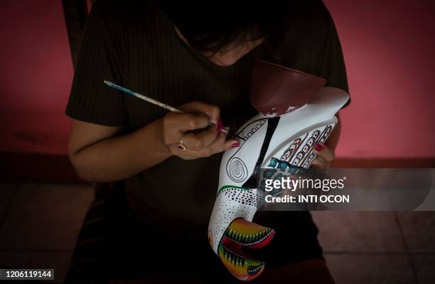 Craftswoman Olga Pena paints handicrafts to sell to tourists, in Mancarron Island, at the Solentiname archipielago, Nicaragua, on March 7, 2020. - In...