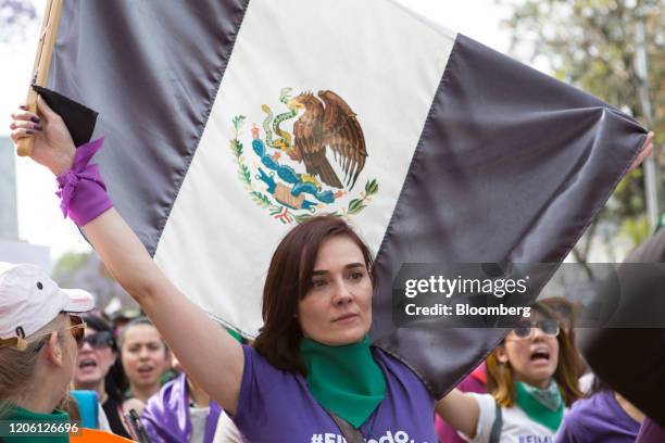 Demonstrator holds an altered version of the Mexican flag during a rally on International Women's Day in Mexico City, Mexico, on Friday, March 8,...