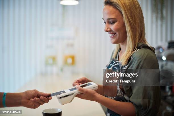 barista holding a contactless payment reader. - datafono stock pictures, royalty-free photos & images