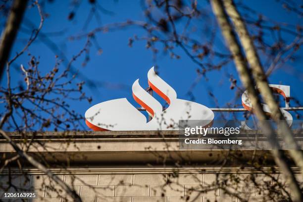 Logo sits on the roof of a Banco Santander SA bank branch in Barcelona, Spain, on Monday, March 9, 2020. Spanish bank shares soared after the...