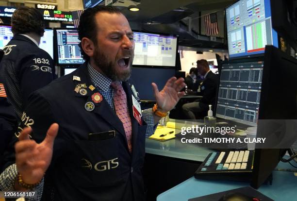 Trader reacts as he works on the floor during the opening bell on the New York Stock Exchange on March 9, 2020 in New York. - Trading on Wall Street...