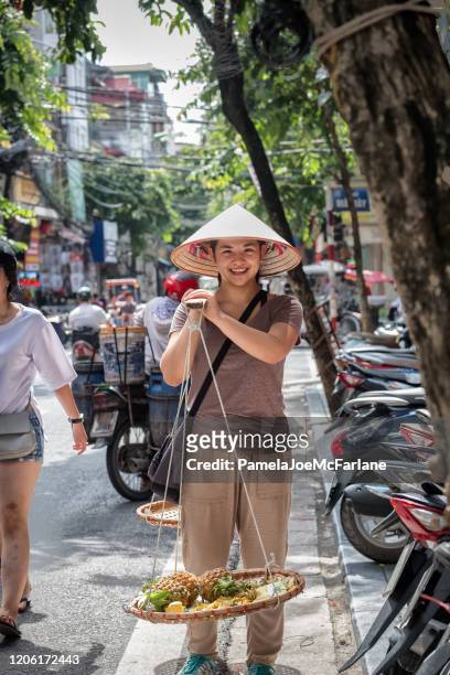 smiling young woman with cut pineapple for sale, hanoi, vietnam - vietnam girls for sale stock pictures, royalty-free photos & images