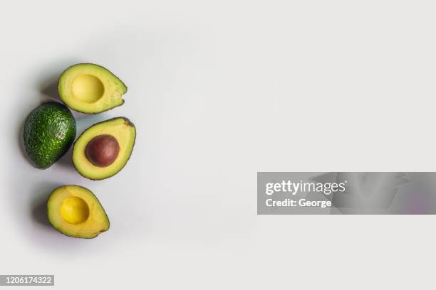 half avocado on gray background - avocado isolated stock-fotos und bilder