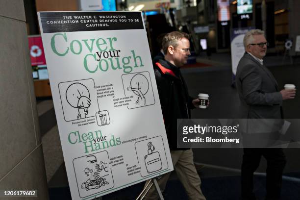 Cover Your Cough" sign is displayed during the Satellite 2020 Conference in Washington, D.C., U.S., on Monday, March 9, 2020. The event comprises...
