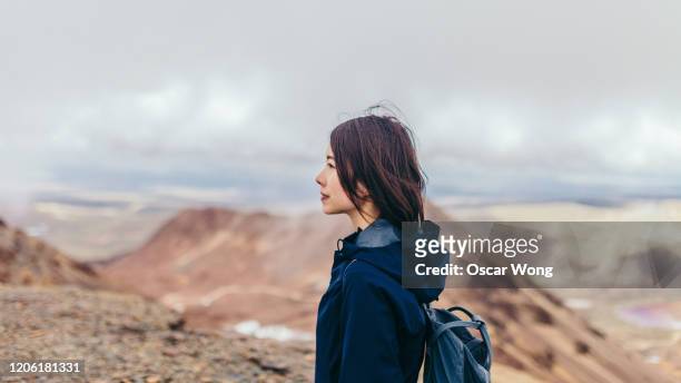 Young Woman Hiking On The Mountain Against Cloudy Sky