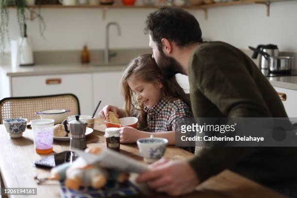 a father and his daughter having their breakfast at home - desayuno familia fotografías e imágenes de stock