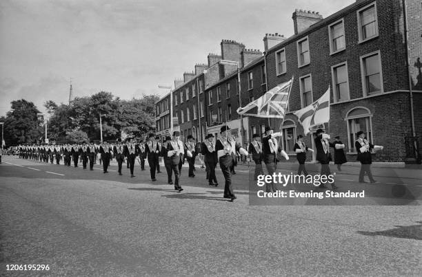 Orange Order members and Orangemen march in a parade, or Orange walk, along a street in Belfast, Northern Ireland on 12th July 1970.