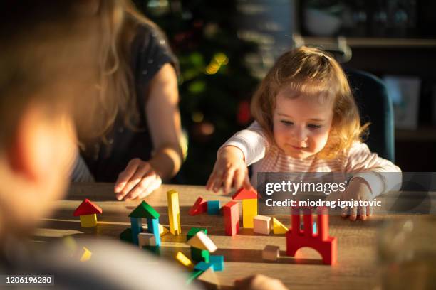 fille d’enfant en bas âge blonde jouant avec des blocs de jouet à la maison - parent denfant adulte photos et images de collection