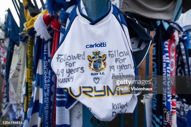 Fans leave scarves, football shirts and banners marking the expulsion of Bury FC from the EFL at Gigg Lane on February 14, 2020 in Bury, United...
