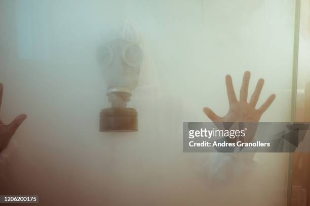man with gas mask having a virus or radioactive disinfection shower - doomsday photos et images de collection