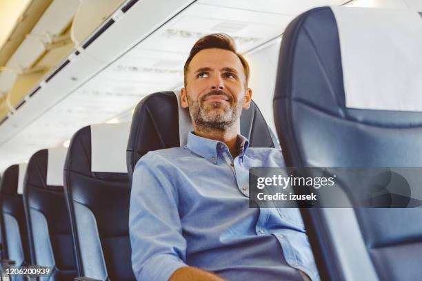 businessman sitting in the airplane - business class seat stock pictures, royalty-free photos & images