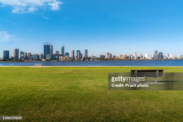 view of perth skyline and business office skyscrapers buliding downtown with chair in public park from swan river in western australia, australia. - western australia imagens e fotografias de stock