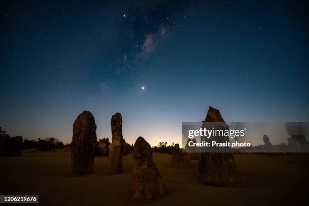 starry milky way at night with large stone in the pinnacles desert during sunrise at nambung national park, western australia., australia. - rocky star stock pictures, royalty-free photos & images