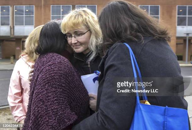 Justyna Zubko-Valva, center, the mother of Thomas Valva, is surrounded by supporters after she finished speaking to reporters outside Suffolk Country...