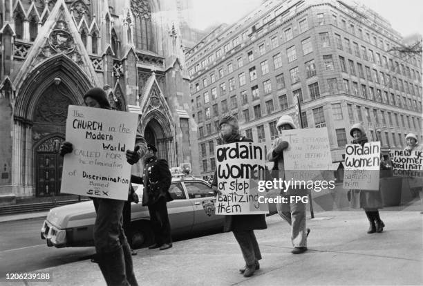 People at a pro women ordination demonstration holding placards which read "The Church in the modern world called for the elimination of...