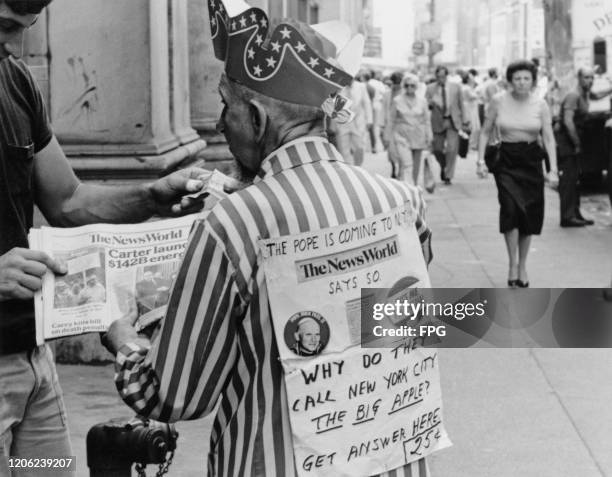 Hungarian-American vaudevillian Joseph Erdelyi Jr, also known as "Uncle Sam", with a sign on his back which reads "The pope is coming to NYC, The...