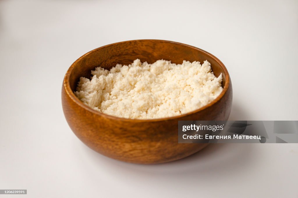 Almond nut crumbs in bamboo wooden bowl on white background isolated