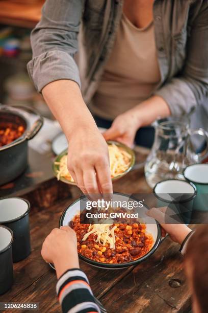 junge familie essen chili con carne - chili con carne stock-fotos und bilder