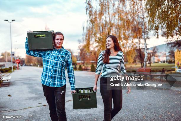 pareja y su enorme carga de cerveza en el camino a una fiesta - crate fotografías e imágenes de stock