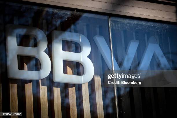 Logo sits on display in the window of a Banco Bilbao Vizcaya Argentaria SA bank branch in Barcelona, Spain, on Saturday, March 7, 2020. Spanish bank...