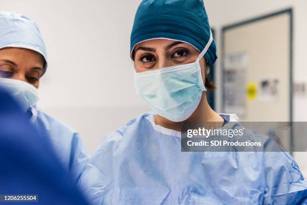 zekere geconcentreerde vrouwelijke chirurg - face mask protective workwear stockfoto's en -beelden