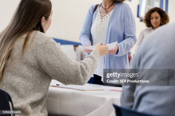 woman receiving ballot on election day - ballot stock pictures, royalty-free photos & images