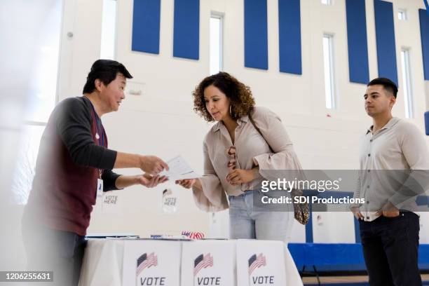 vallokal volontär förklarar omröstning till väljarna - röstregistrering bildbanksfoton och bilder