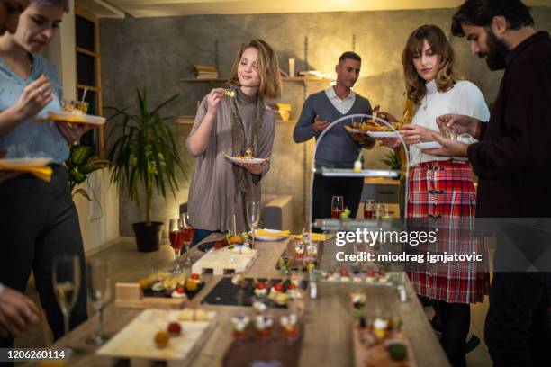 business team enjoying small talk and food during after work banquet - small dinner party stock pictures, royalty-free photos & images