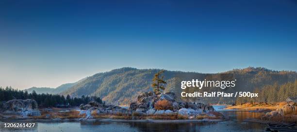 clear sky over forest and lake with rocks, big bear lake, california, usa - big bear lake stock pictures, royalty-free photos & images