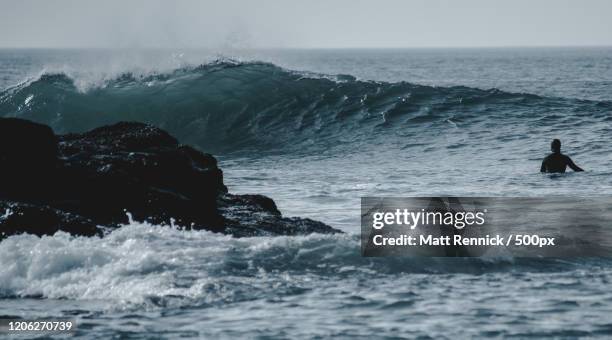 view of surfer in wavy sea, bundoran, republic of ireland - bundoran ireland stock pictures, royalty-free photos & images