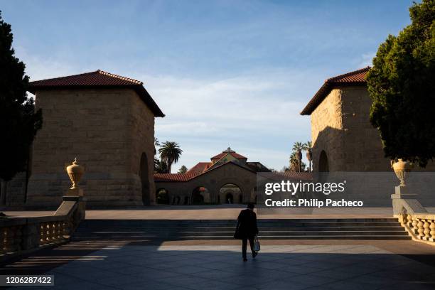 Person walks towards the main quad during a quiet morning at Stanford University on March 9, 2020 in Stanford, California. Stanford University...