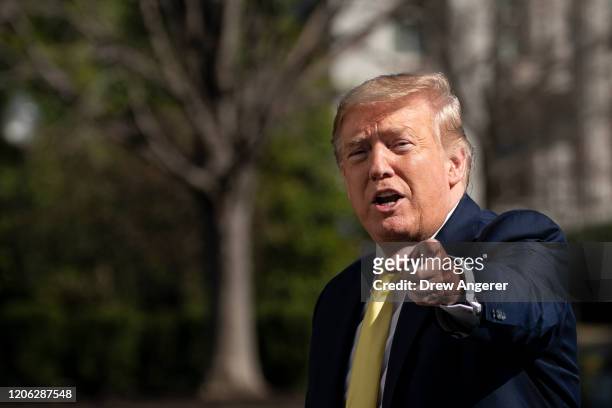 President Donald Trump gestures as he walks toward the White House residence after exiting Marine One on the South Lawn of the White House March 9,...