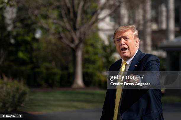 President Donald Trump gestures as he walks toward the White House residence after exiting Marine One on the South Lawn of the White House March 9,...