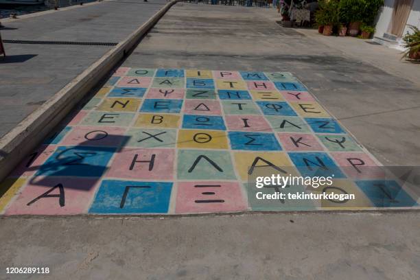 greek alphabet child game lagkada village coast at chios island in aegean sea of greece - ancient greek alphabet stock pictures, royalty-free photos & images