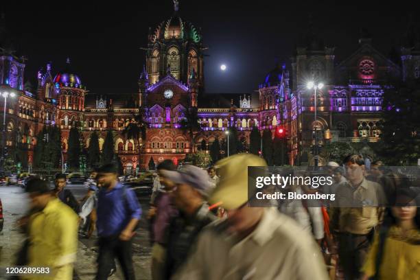 Pedestrians walk past the Chhatrapati Shivaji Terminus railway station in Mumbai, India, on Monday, March 9, 2020. India's central bank seizing...