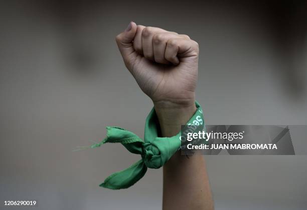 Woman rises her fist with a green headscarves to demand the legalization of abortion during a demonstration in front of the Congress during a women...