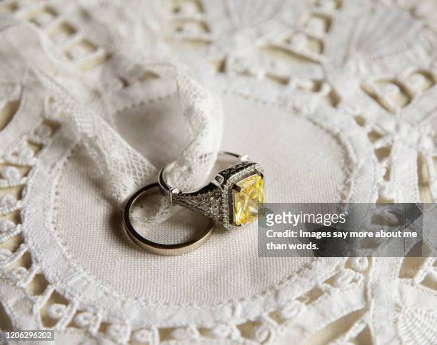 a yellow diamond ring surrounded by lace. still life - 50th anniversary background stock pictures, royalty-free photos & images