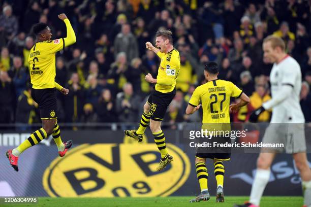 Lukas Piszczek of Dortmund celebrates his team's first goal with team mates Dan-Axel Zagadou and Emre Can as Sebastian Rode of Frankfurt reacts...